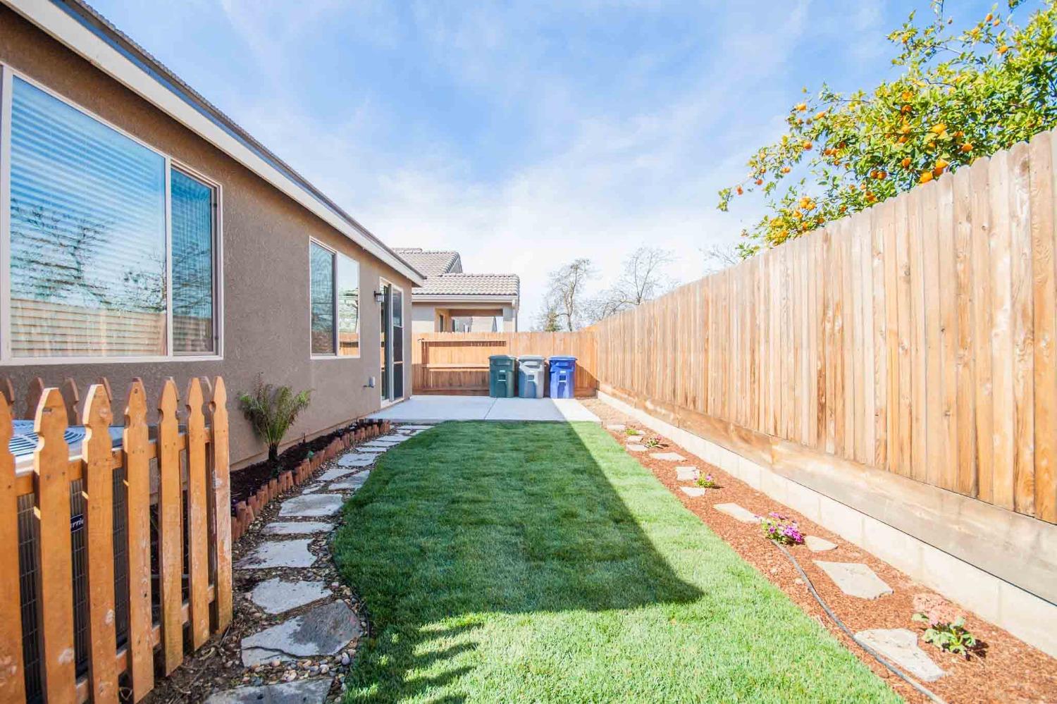 3439 Brimhall Lane Clovis, CA 93619 - Photo 38 of 43 a backyard with potted plants and a wooden bench