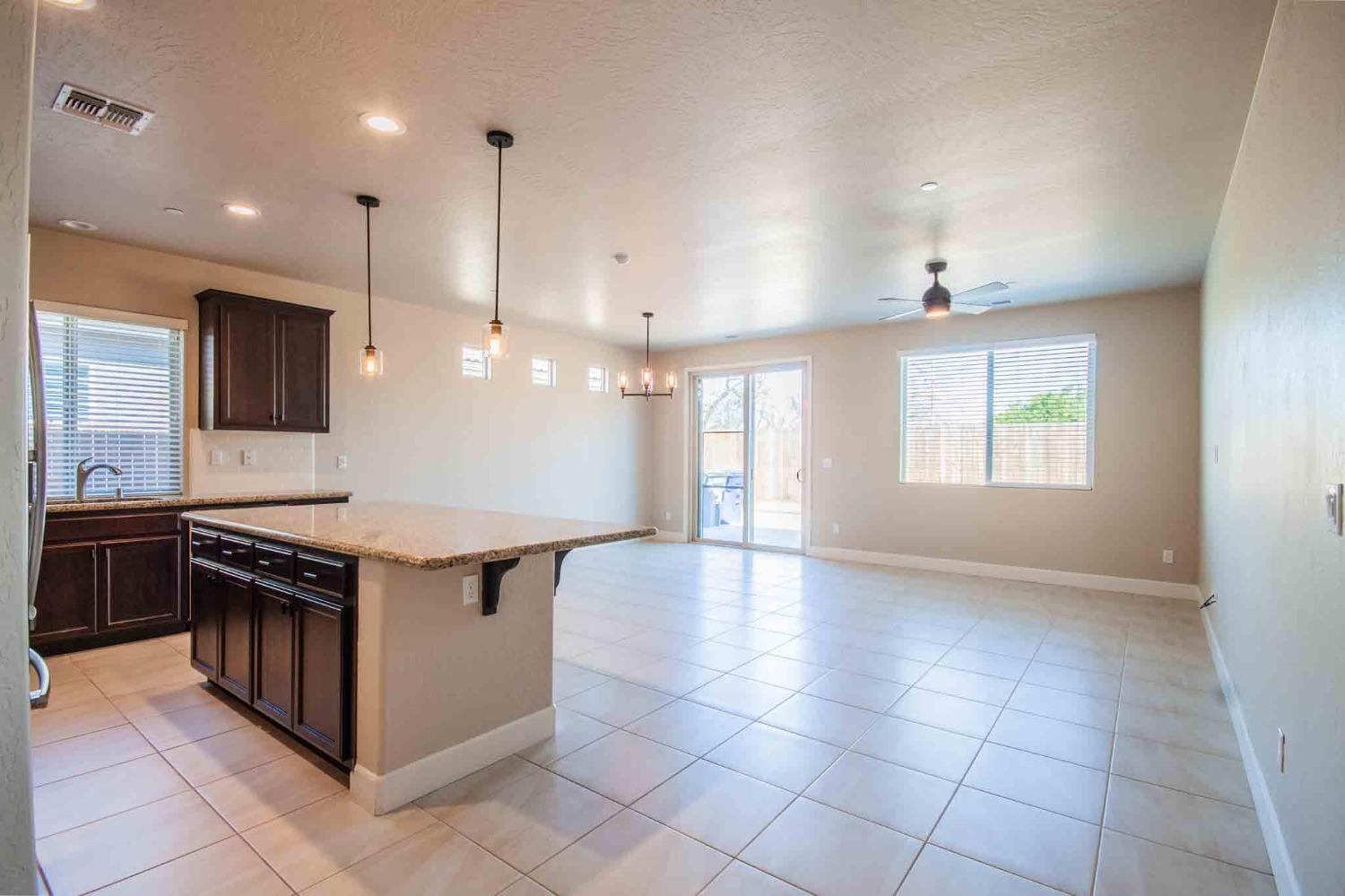 3439 Brimhall Lane Clovis, CA 93619 - Photo 7 of 43 a kitchen with kitchen island granite countertop a stove a sink and a refrigerator