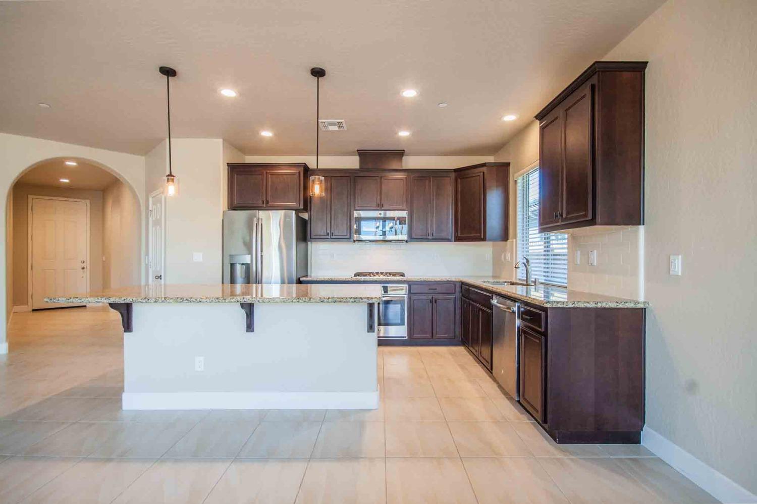 3439 Brimhall Lane Clovis, CA 93619 - Photo 8 of 43 a large kitchen with stainless steel appliances kitchen island a large counter top and a sink