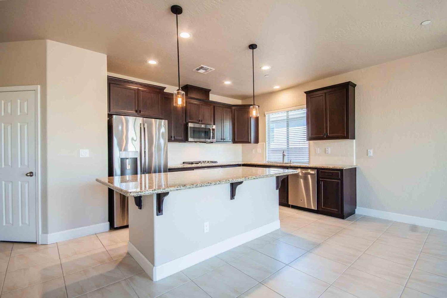 3439 Brimhall Lane Clovis, CA 93619 - Photo 9 of 43 a large kitchen with kitchen island a sink stainless steel appliances and cabinets