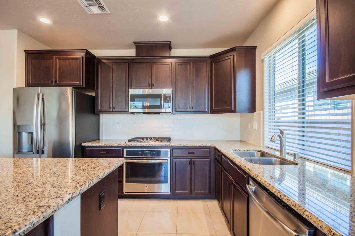 3439 Brimhall Lane Clovis, CA 93619 - Photo 10 of 43 a kitchen with stainless steel appliances granite countertop a sink stove microwave and refrigerator