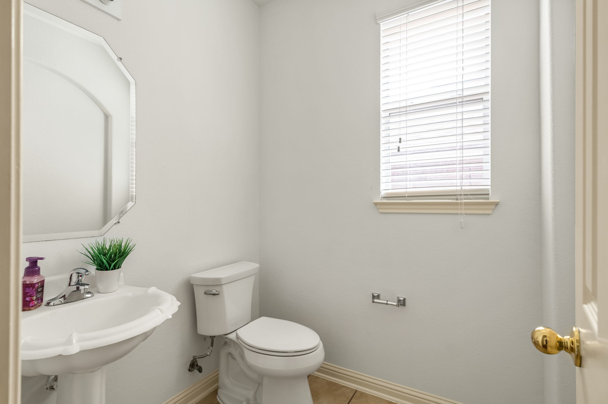 10004 Isle Royale Way Austin, TX 78747 - Photo 14 of 31 A well-lit powder room offers functional design and natural illumination.