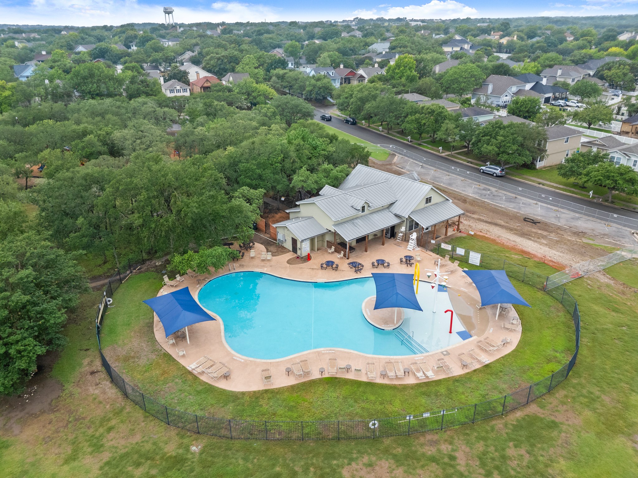 360 Sampson Kyle, TX 78640 - Photo 27 of 36 Resort-style pool area featuring a clubhouse with covered patio, multiple shade structures, and surrounding green space