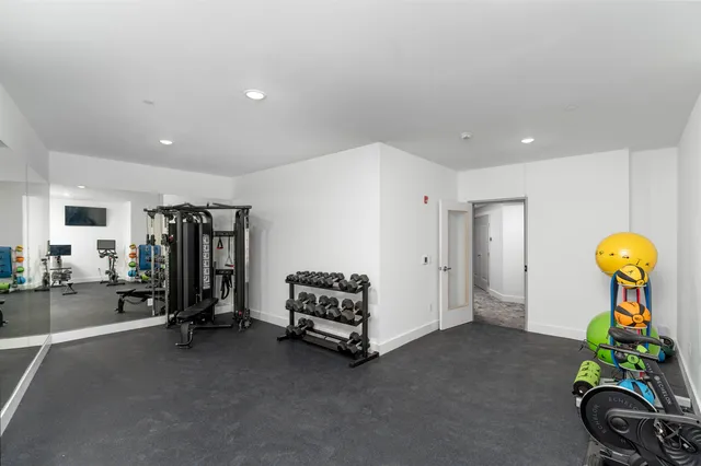 a living room with gym equipment and a chandelier