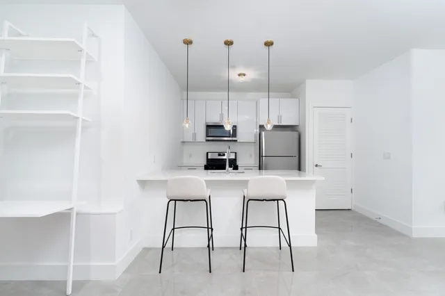 a kitchen with a table chairs refrigerator and microwave