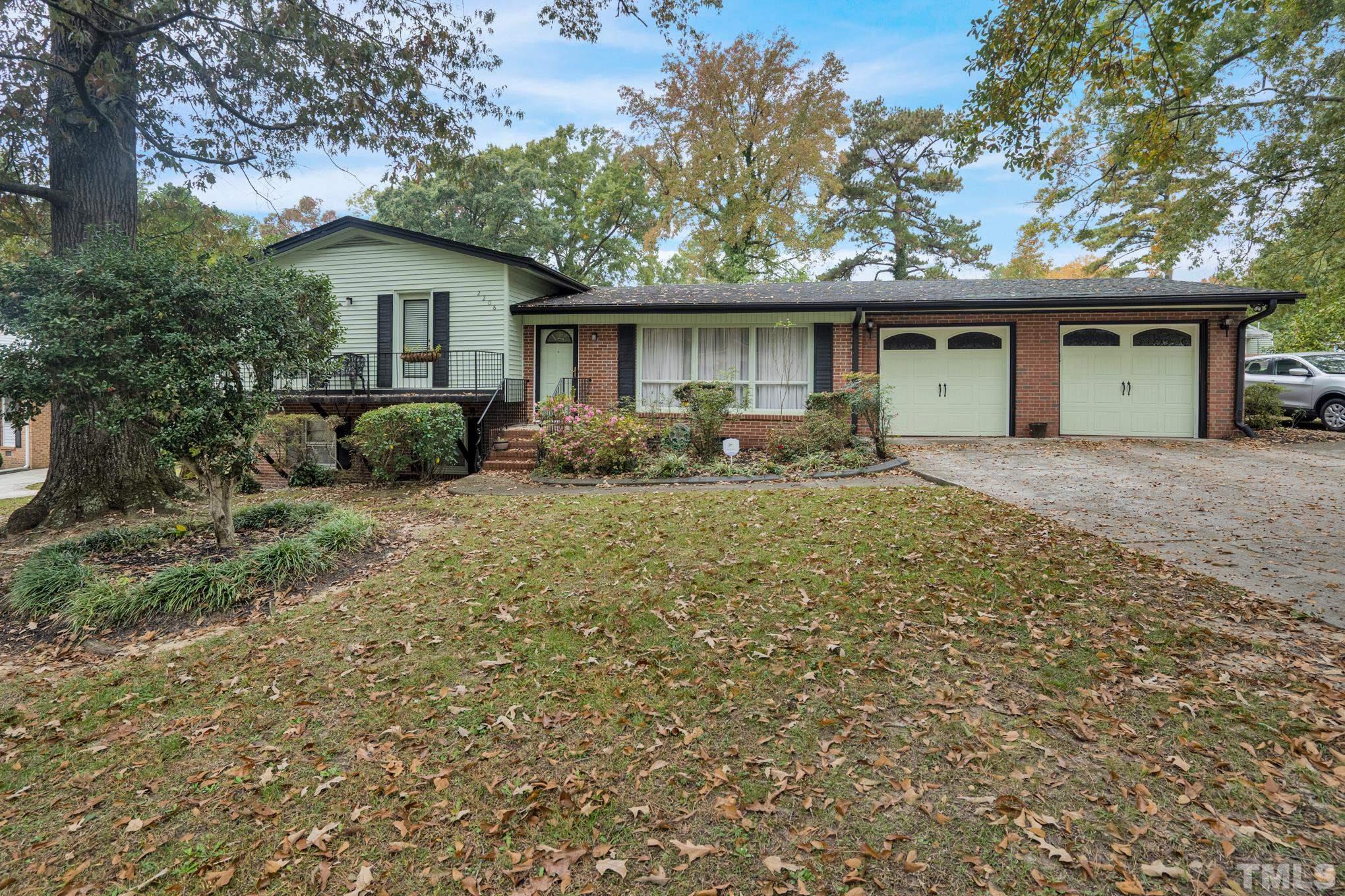 2206 Lyndhurst Drive Raleigh, NC 27610 - Photo 1 of 17 a front view of a house with a yard and garage