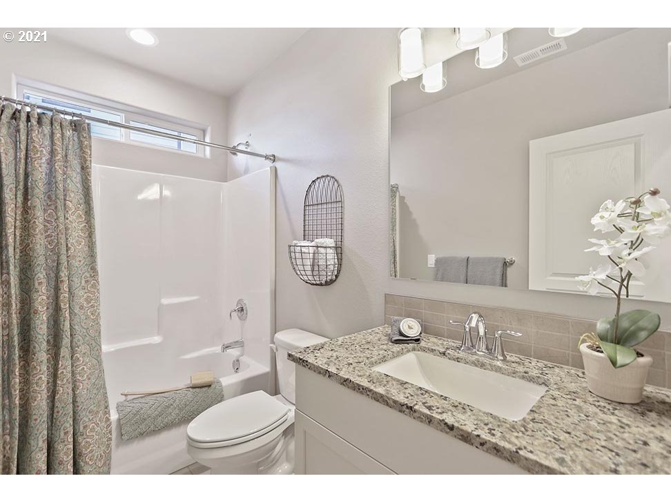5266 Squirrel Street Springfield, OR 97478 - Photo 2 of 15 a bathroom with a granite countertop sink toilet mirror vanity and shower
