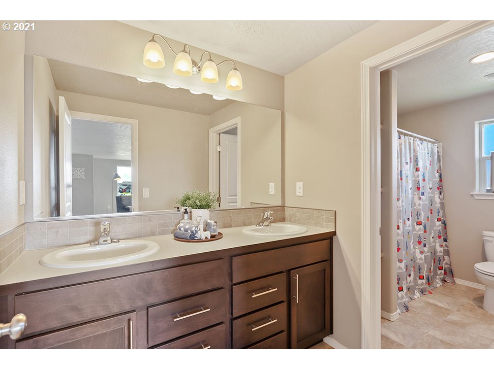 5266 Squirrel Street Springfield, OR 97478 - Photo 13 of 15 a bathroom with a granite countertop sink a large mirror and a shower