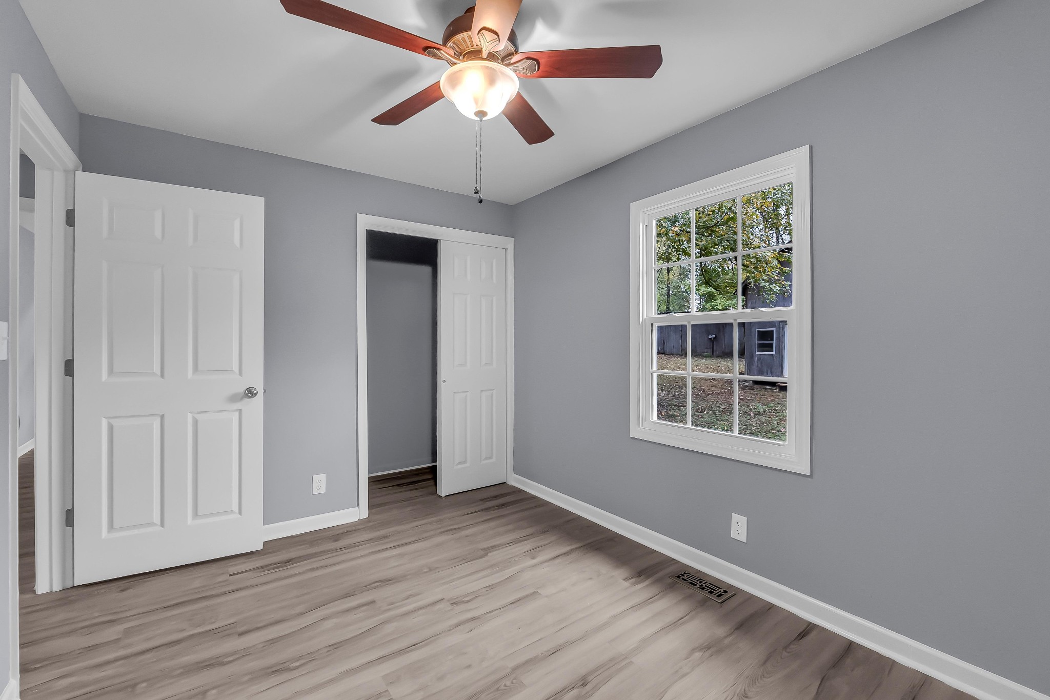 99 Anthony Mill Road Tullahoma, TN 37388 - Photo 22 of 37 an empty room with wooden floor chandelier fan and windows
