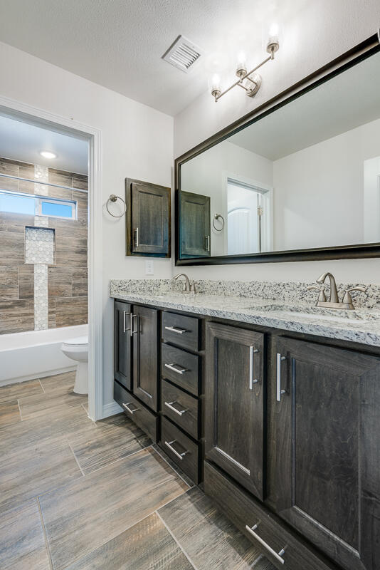 103 Water Tank Road Sunland Park, NM 88008 - Photo 20 of 22 a spacious bathroom with a granite countertop sink and a mirror