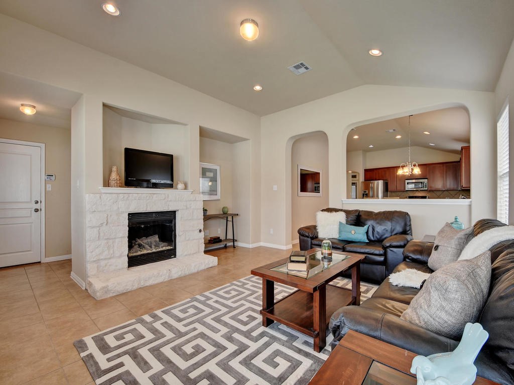 a living room with furniture a fireplace and a flat screen tv