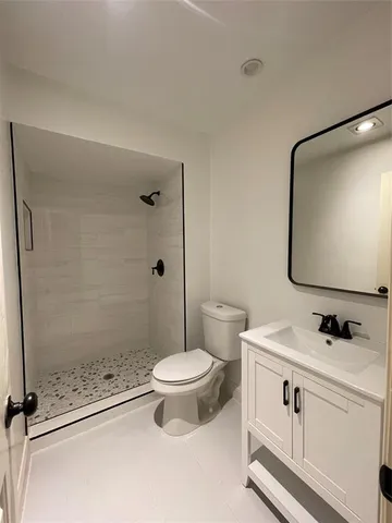 a bathroom with a sink a toilet and shower