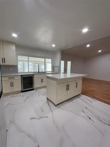 a large kitchen with granite countertop a stove a sink and a microwave