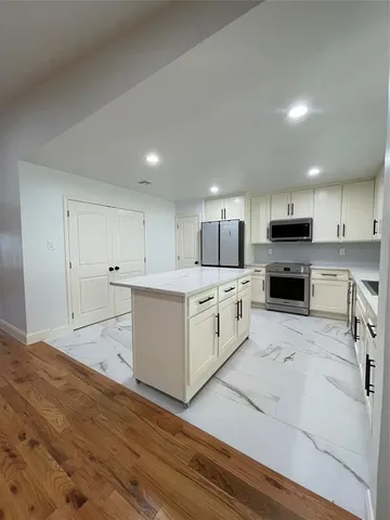 a kitchen with white cabinets and stainless steel appliances