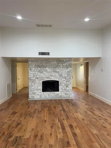 an empty room with wooden floor and fireplace