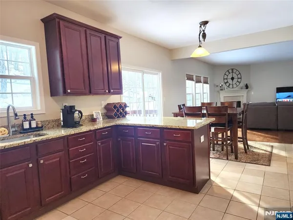 a kitchen with stainless steel appliances granite countertop wooden cabinets a dining table and chairs
