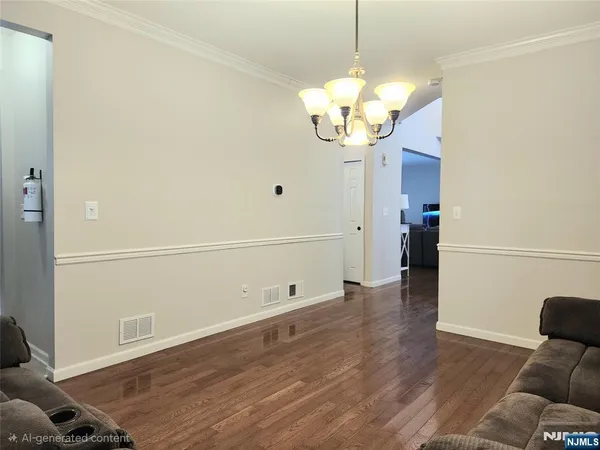a view of a room with wooden floor and chandelier