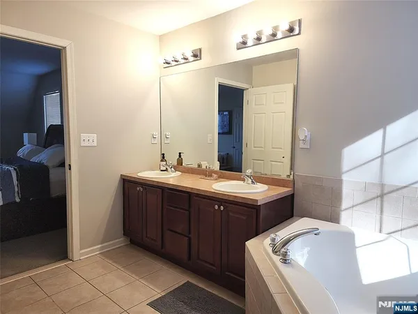 a bathroom with a tub sink and mirror
