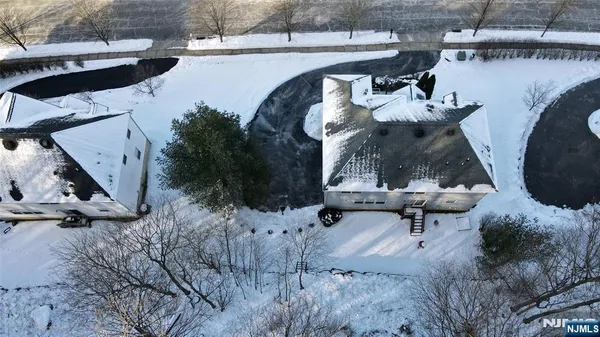 a view of a white house with a large tree