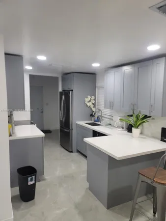 a kitchen with a sink refrigerator and cabinets