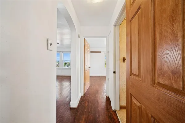 a view of a hallway with wooden floor and staircase