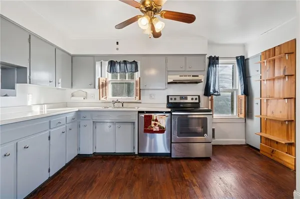 a kitchen with stainless steel appliances a stove a sink and white cabinets