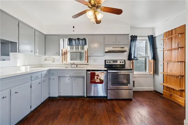 a kitchen with stainless steel appliances a stove a sink and white cabinets