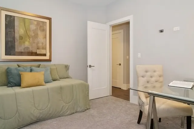 a living room with a couch and a potted plant on the wall