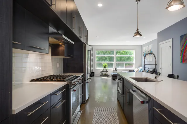 a kitchen that has a sink stainless steel appliances a counter space and a window