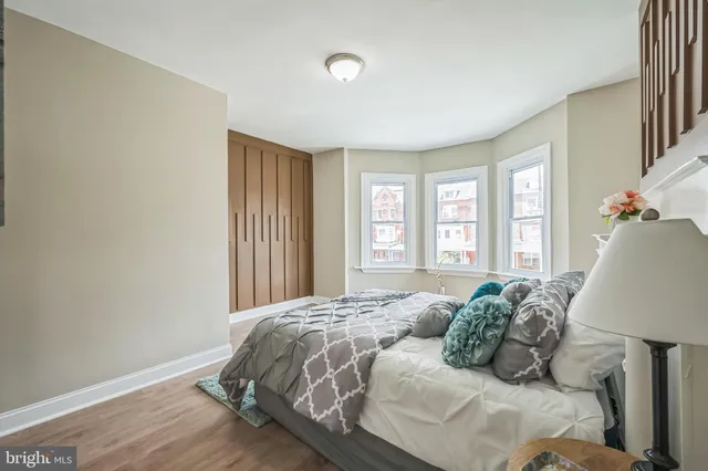 a bed sitting in a spacious bedroom next to a window