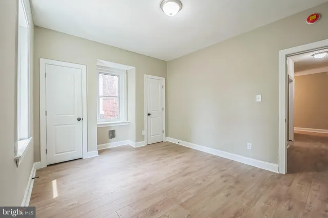 an empty room with windows and closet