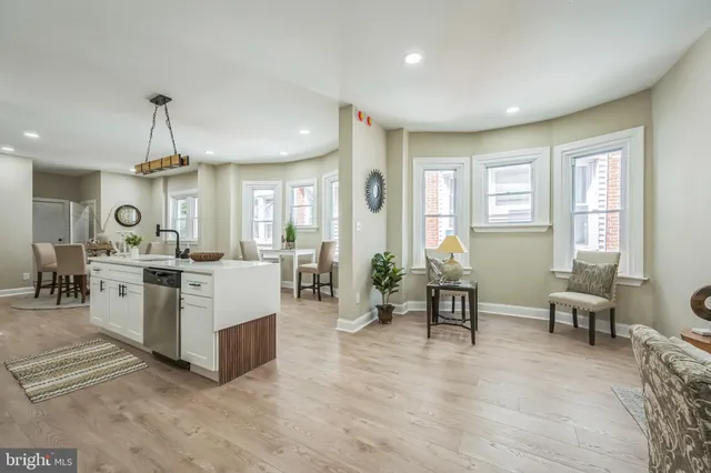 a living room with furniture a dining table and chairs with wooden floor