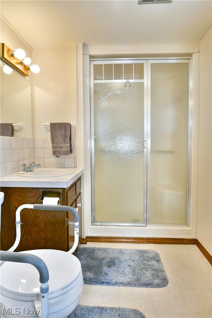 2713 Ridge Road Cortland, OH 44410 - Photo 29 of 35 Bathroom with walk in shower, vanity, backsplash, toilet, and tile flooring