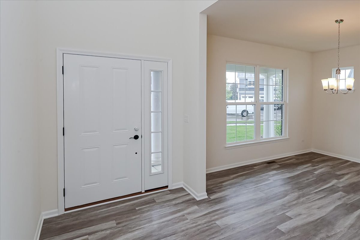 10782 Chadsey Road Huntley, IL 60142 - Photo 2 of 33 a view of an empty room with window and wooden floor