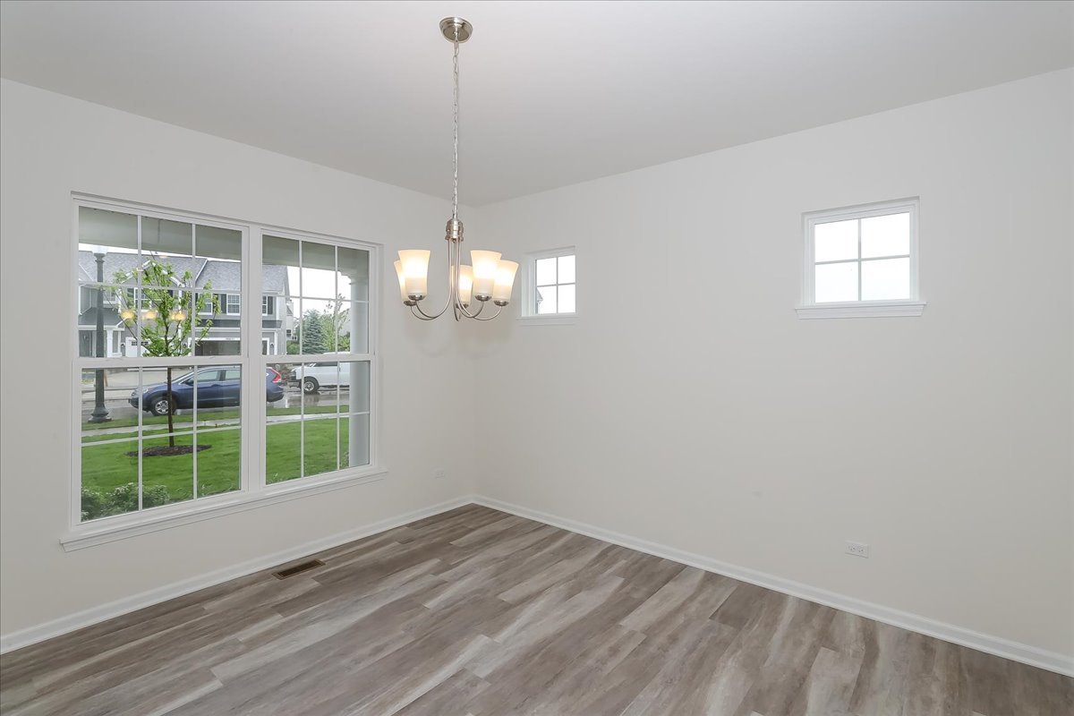 10782 Chadsey Road Huntley, IL 60142 - Photo 3 of 33 a view of empty room with wooden floor and fan