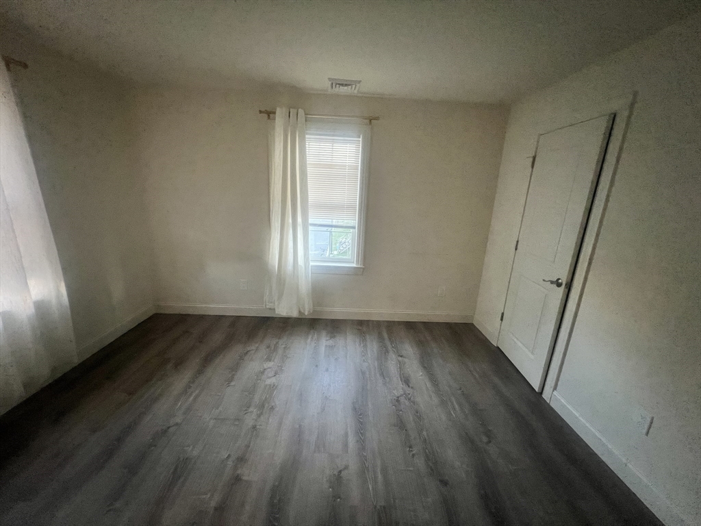 51 Everit Avenue, Unit B Framingham, MA 01702 - Photo 3 of 14 an empty room with wooden floor and windows