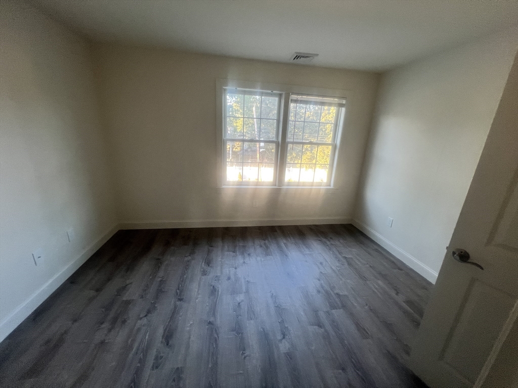 51 Everit Avenue, Unit B Framingham, MA 01702 - Photo 8 of 14 an empty room with wooden floor and windows