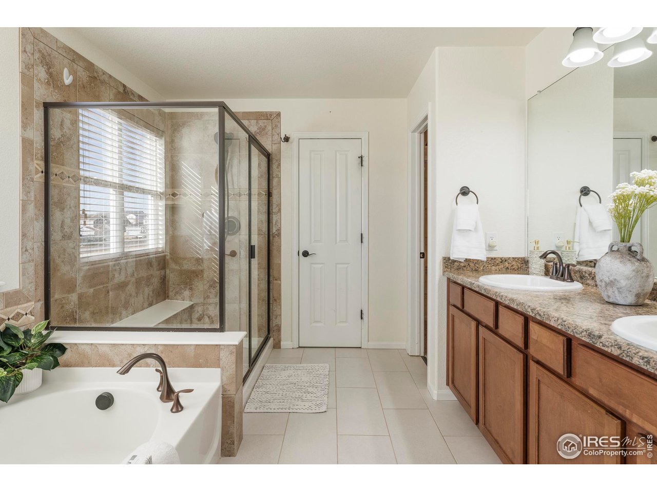 13420 Spruce Street Thornton, CO 80602 - Photo 23 of 48 a bathroom with a granite countertop sink a mirror and shower