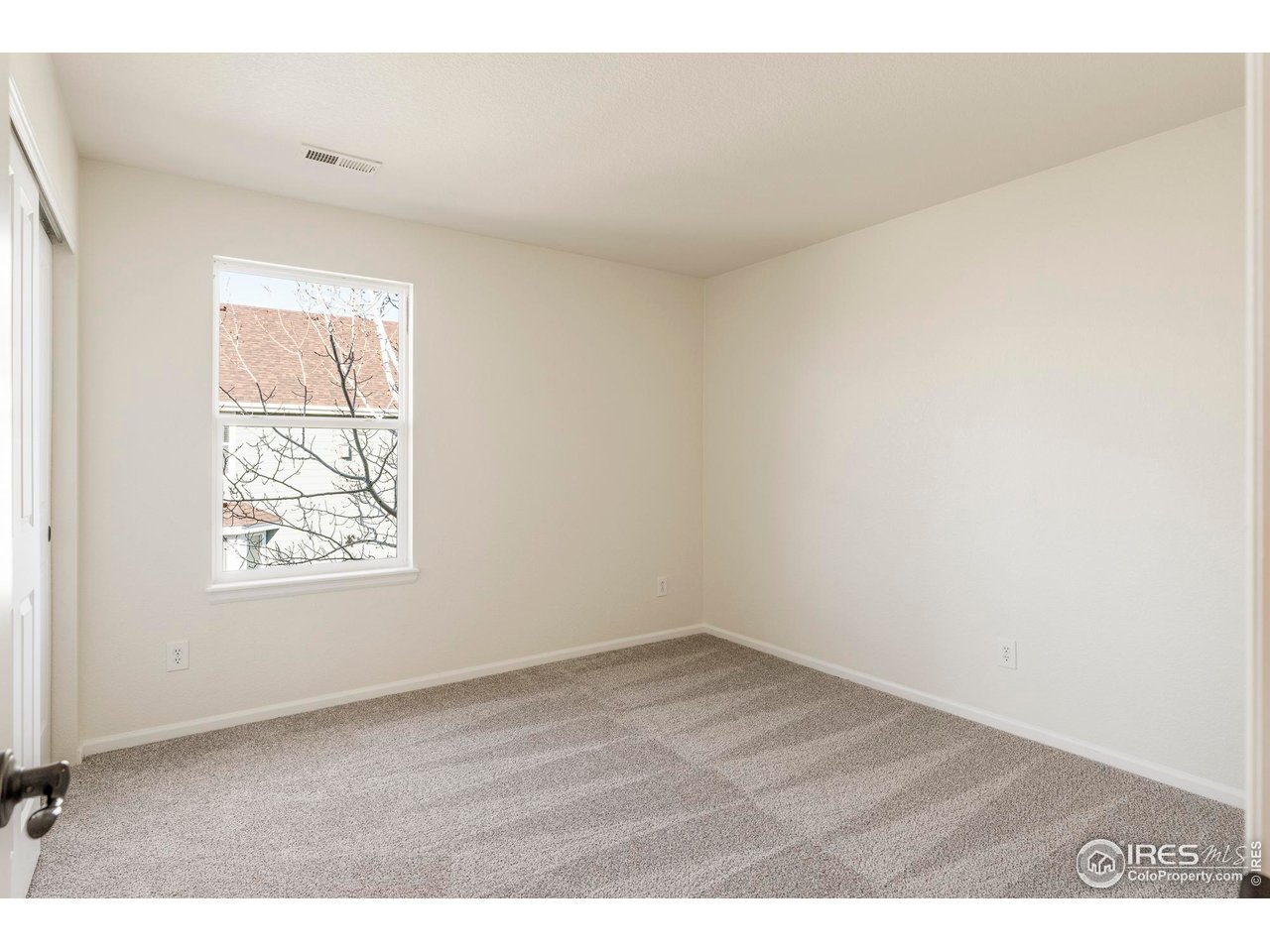 13420 Spruce Street Thornton, CO 80602 - Photo 32 of 48 an empty room with wooden floor and windows