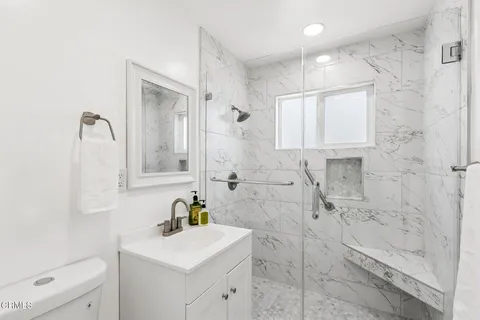 a bathroom with a sink toilet a mirror and shower