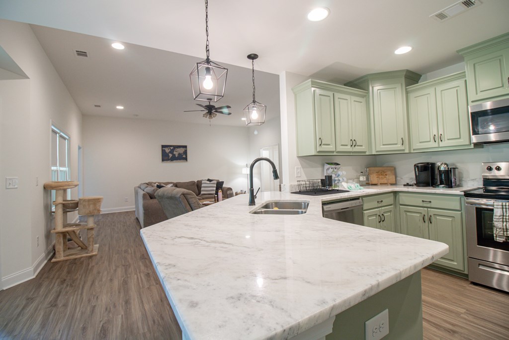 25 Veterans Court Fort Mitchell, AL 36856 - Photo 12 of 32 a large kitchen with kitchen island a stove a sink a center island and wooden floor