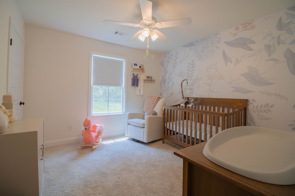 25 Veterans Court Fort Mitchell, AL 36856 - Photo 14 of 32 a bedroom with a bed and a chandelier