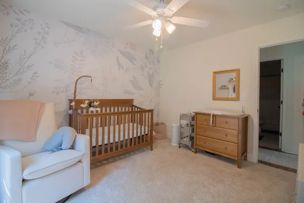 a bedroom with a baby bed baby crib and a couch