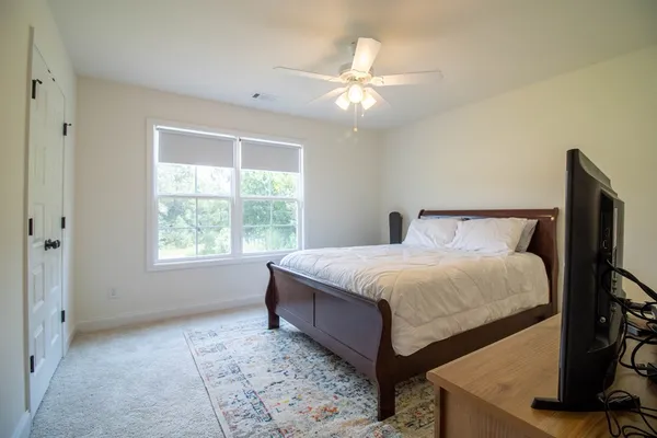 a large bed sitting in a room next to a window