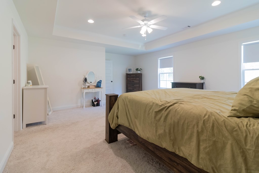 25 Veterans Court Fort Mitchell, AL 36856 - Photo 24 of 32 a spacious bedroom with a bed and a chandelier