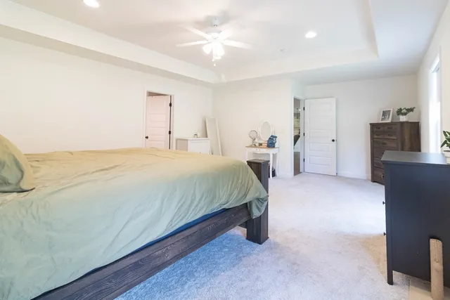 a spacious bedroom with a bed and a chandelier
