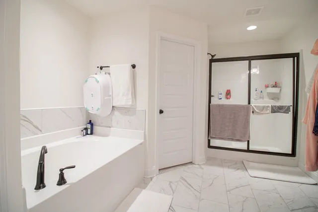 a bathroom with a bathtub sink and mirror