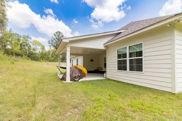 a view of a house with backyard and porch