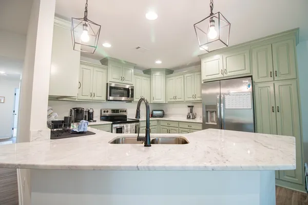a kitchen with stainless steel appliances granite countertop a sink refrigerator and microwave