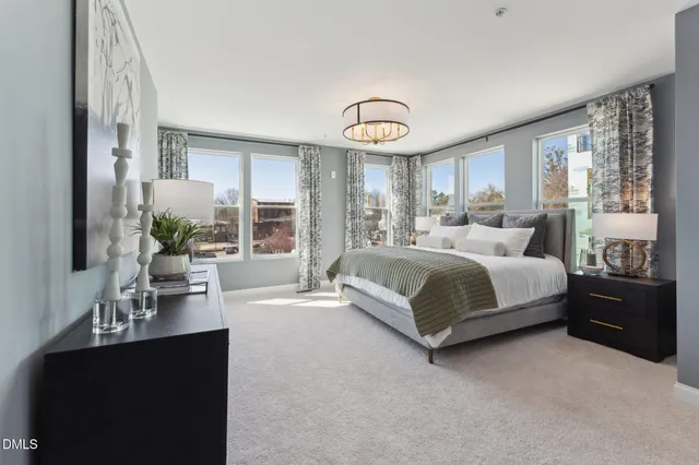 a bedroom with a large bed and a chandelier